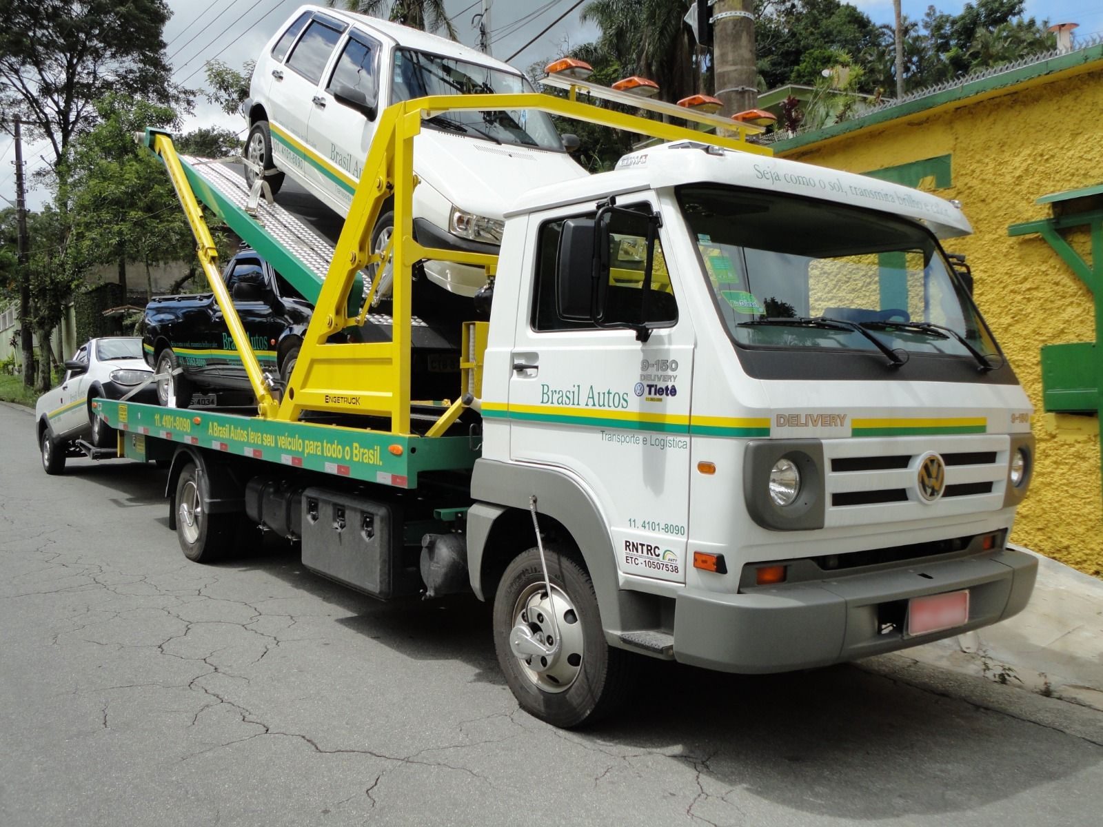 Caminhão plataforma da Brasil Autos transportando um sedan em rodovia brasileira